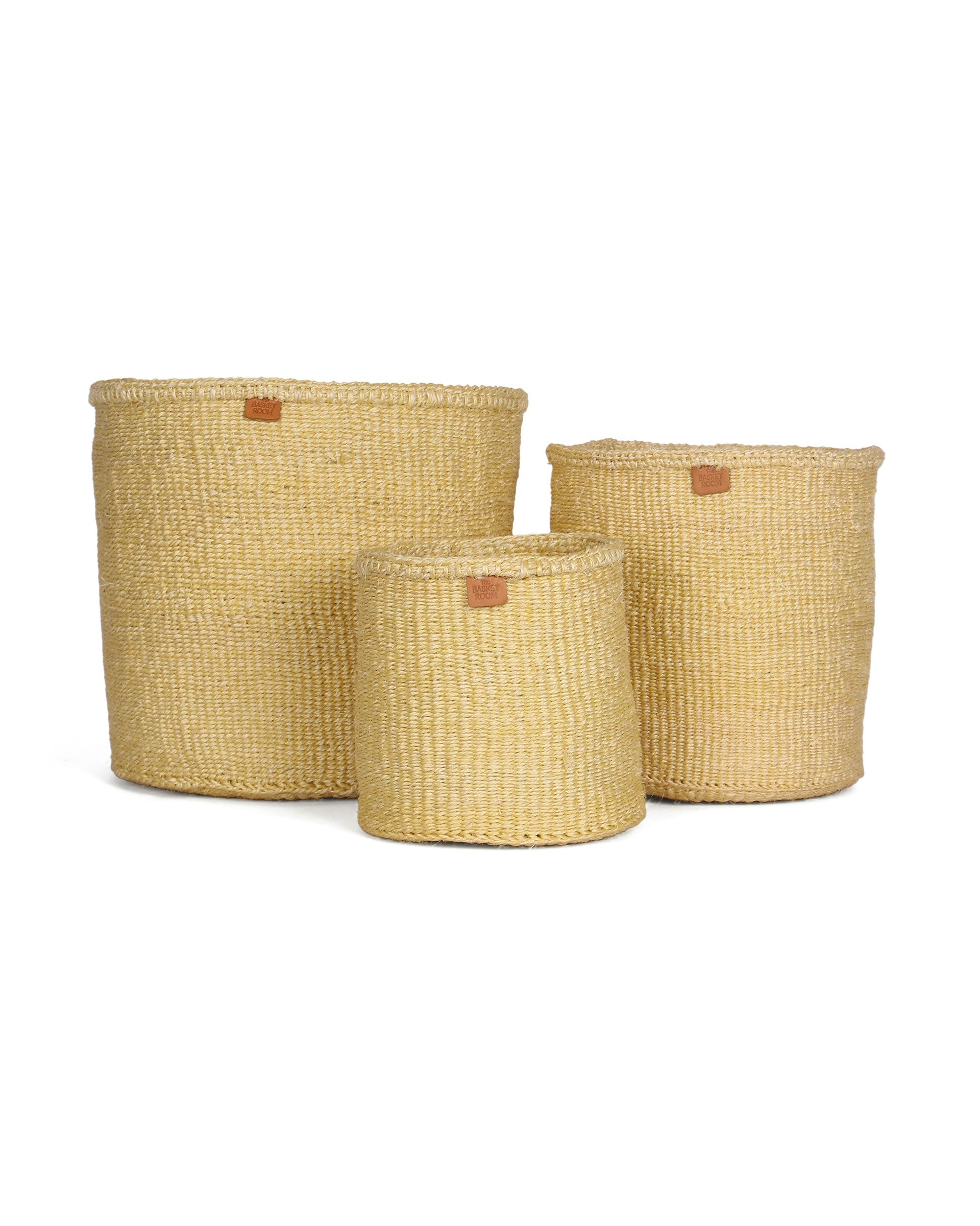 Three woven yellow baskets of different sizes on a white background