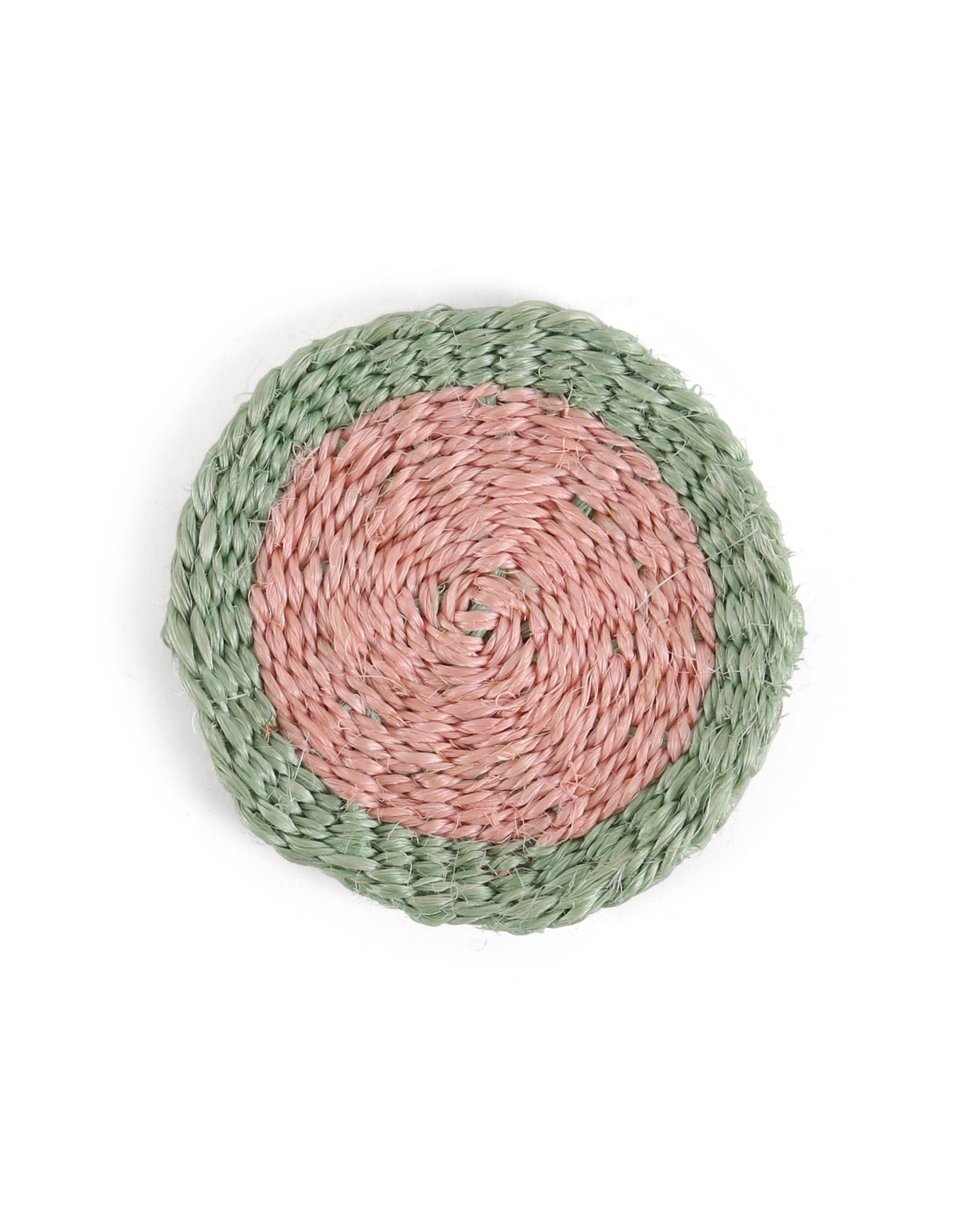 Round woven coaster with pink center and green rim on a white background