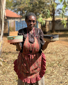 Woman holding two woven baskets outdoors with a rustic background