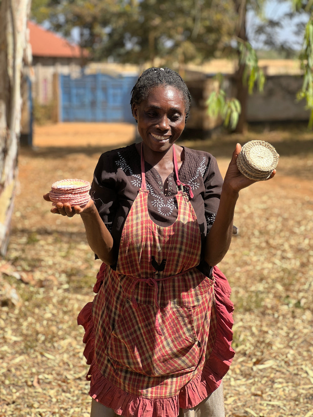 Woman holding woven baskets outdoors with a rustic background